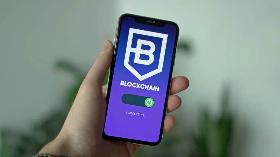 Vue rapprochée d’un ordinateur portable affichant la page de connexion Twitter, accompagné d’un smartphone et d’une plante en pot dans un espace de travail lumineux.